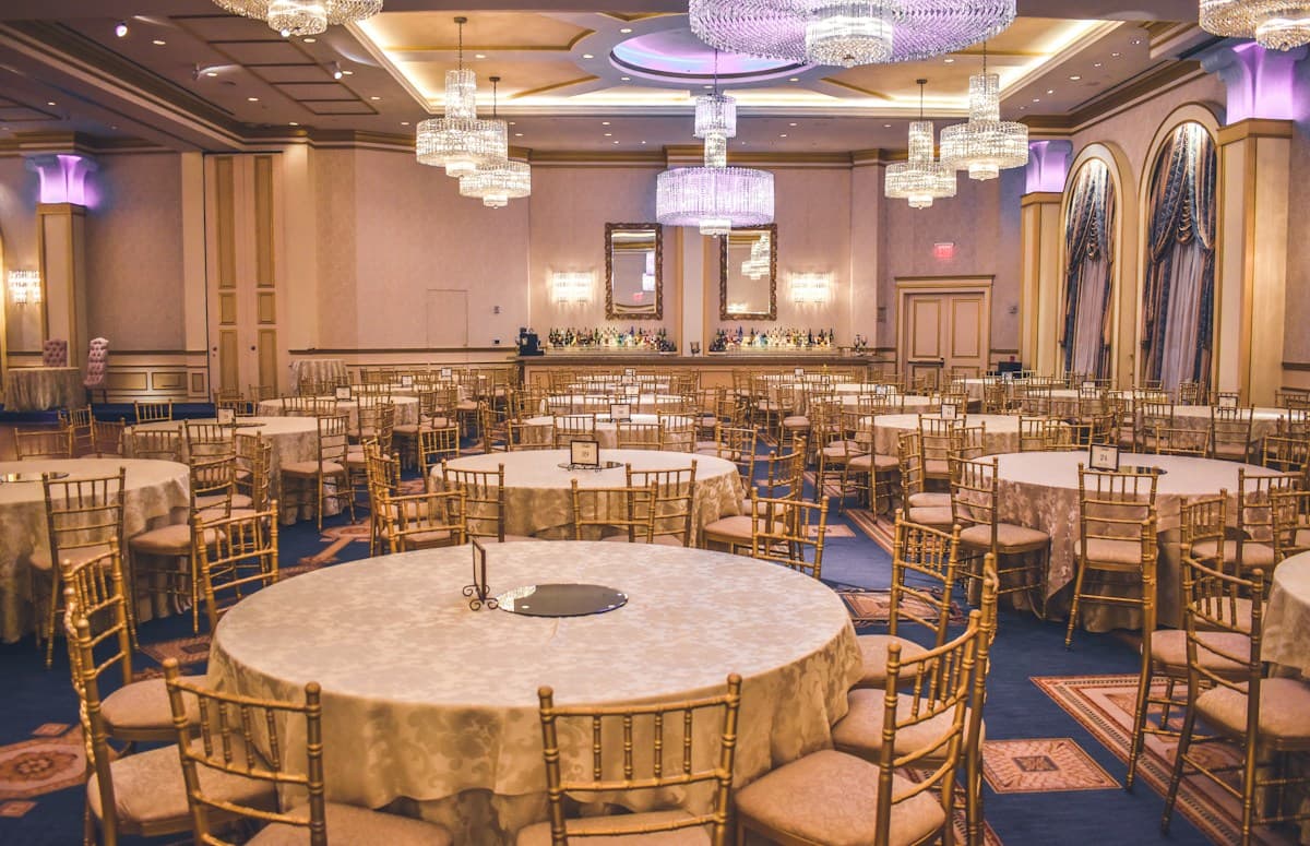 Grand ballroom with banquet round tables and crystal chandeliers