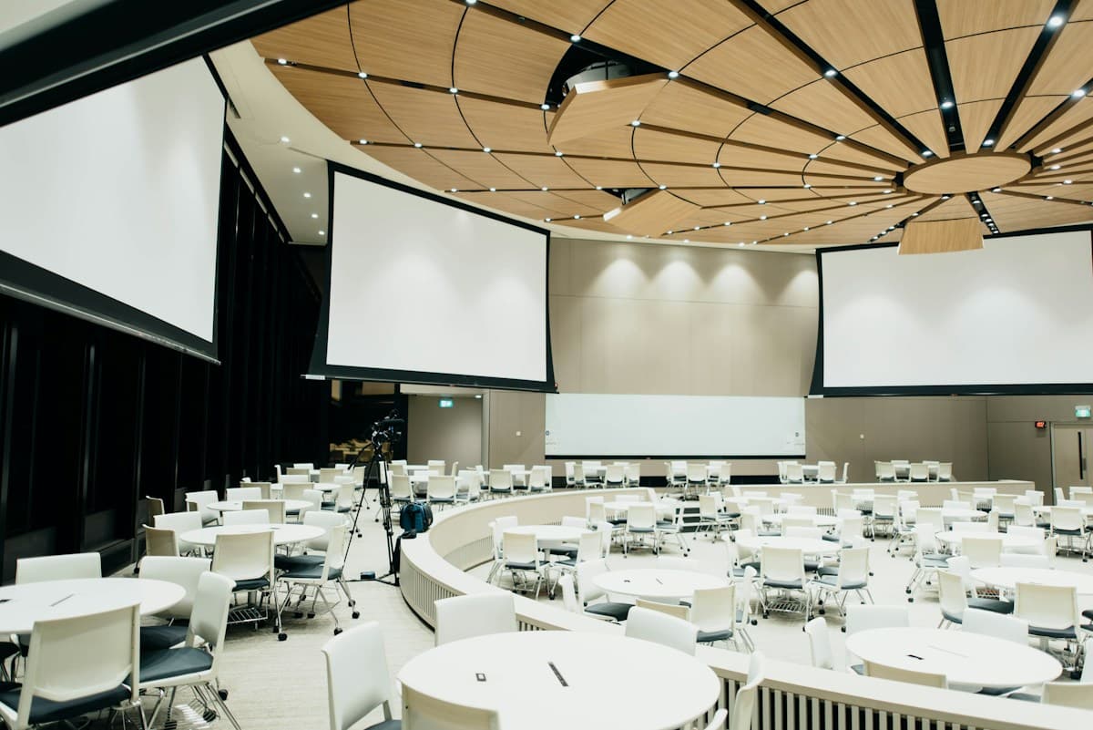 Curved contemporary plenary auditorium with presentation displays